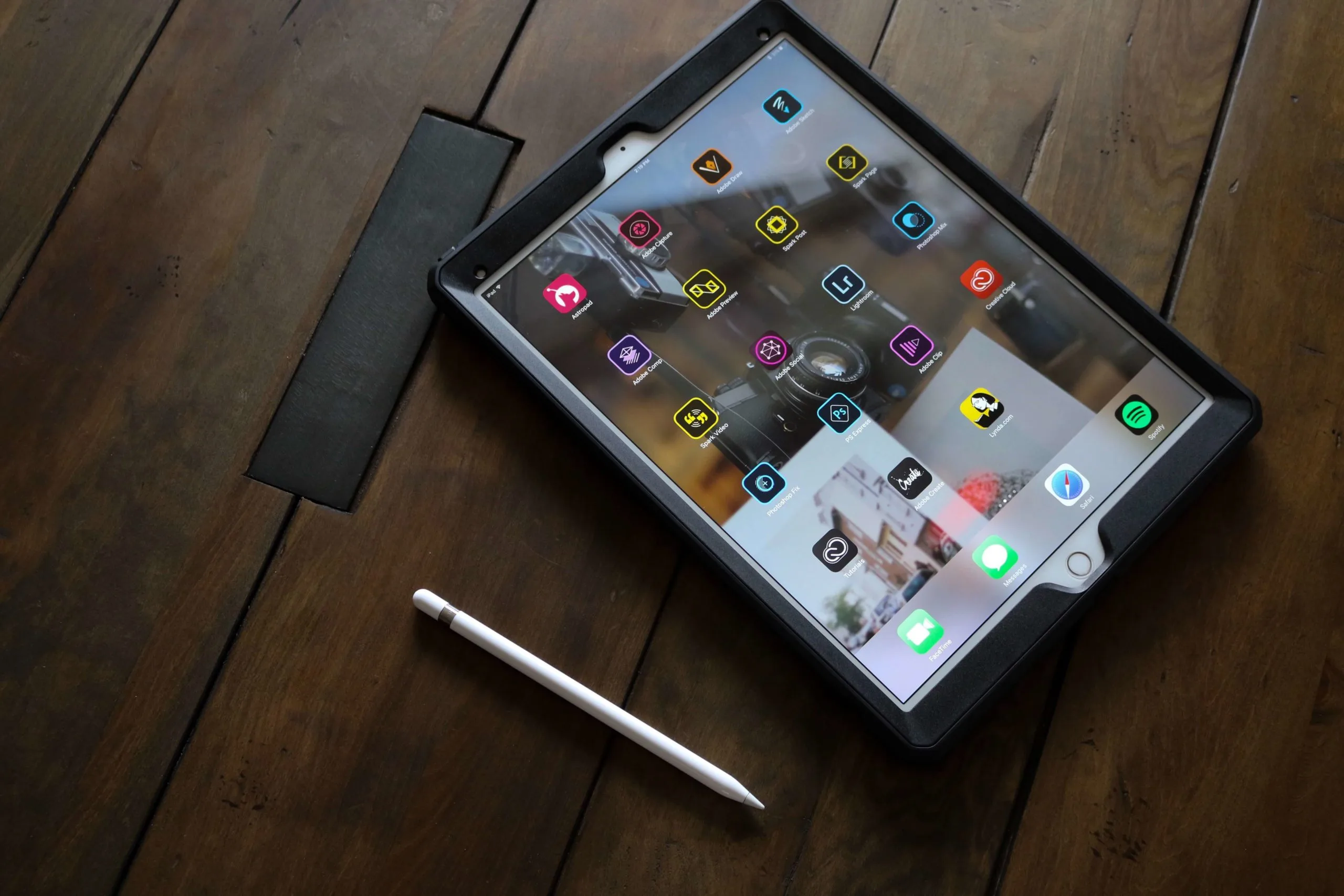 iPad amb Apple Pencil mostrant apps instal·lades sobre taula de fusta