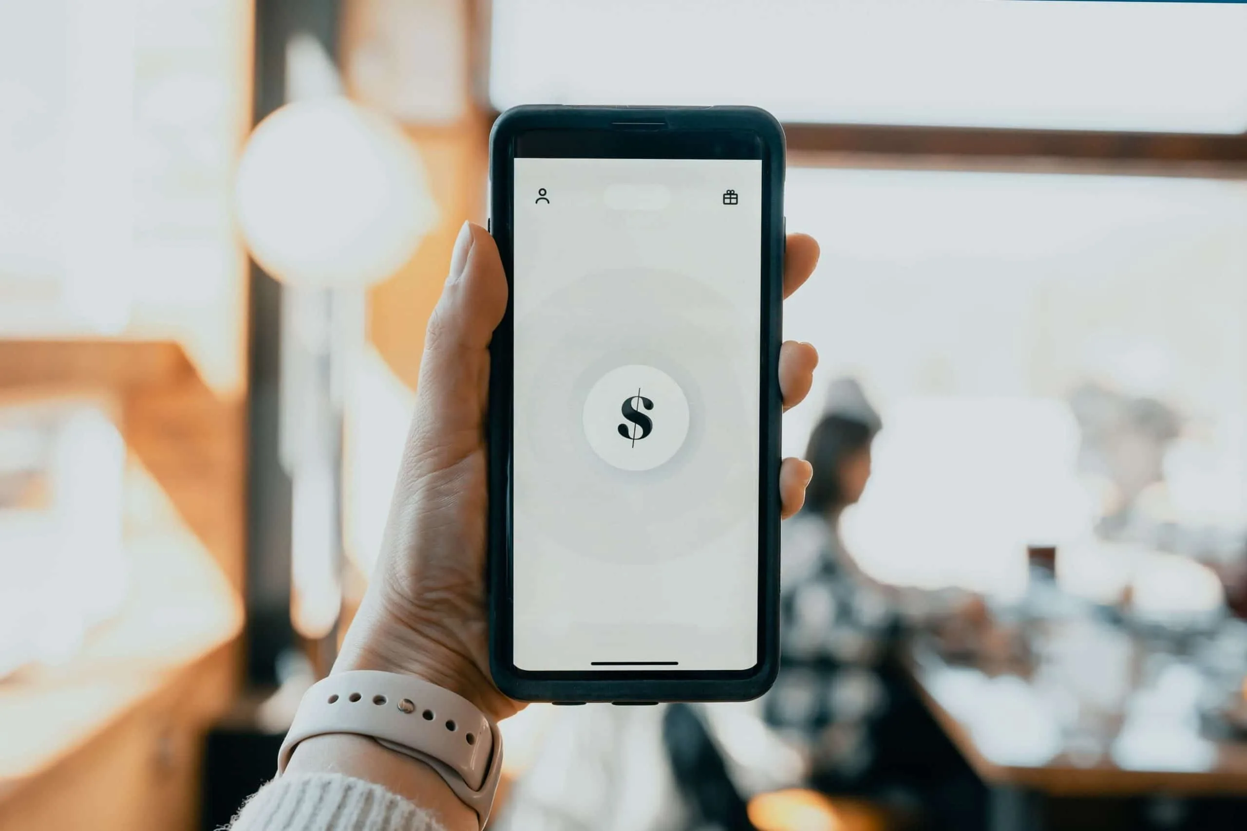 Mà sostenint mòbil amb app de pagaments pel negoci en una cafeteria